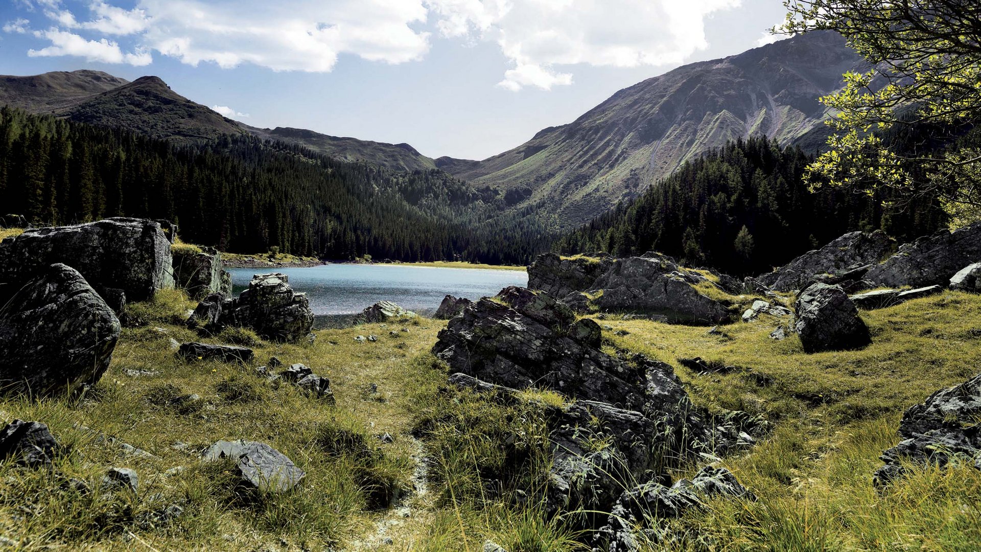 Dein Parkhotel in Matrei am Brenner Berglandschaft mit See, Felsen und bewölktem Himmel