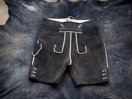 By car to Italy: stopover in Wipptal Black traditional leather shorts with light trim on animal hide