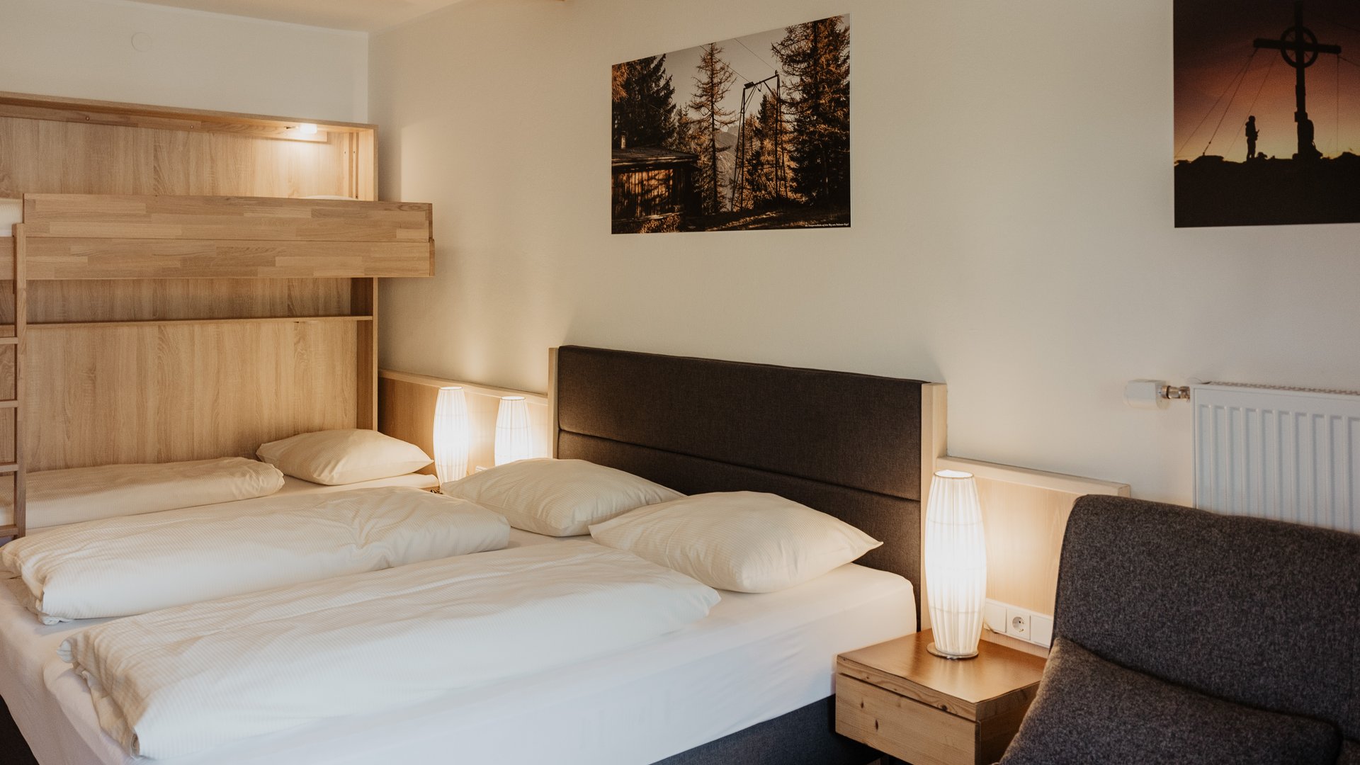 Dein Parkhotel in Matrei am Brenner Gemütliches Schlafzimmer mit Doppelbett, Stockbett und warmen Lampen