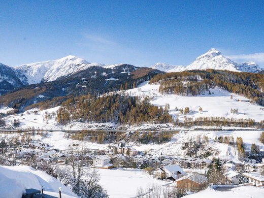 Herzlich willkommen in unserem Hotel in Matrei am Brenner Schneebedeckte Alpenlandschaft mit Dorf und Bergen unter blauem Himmel