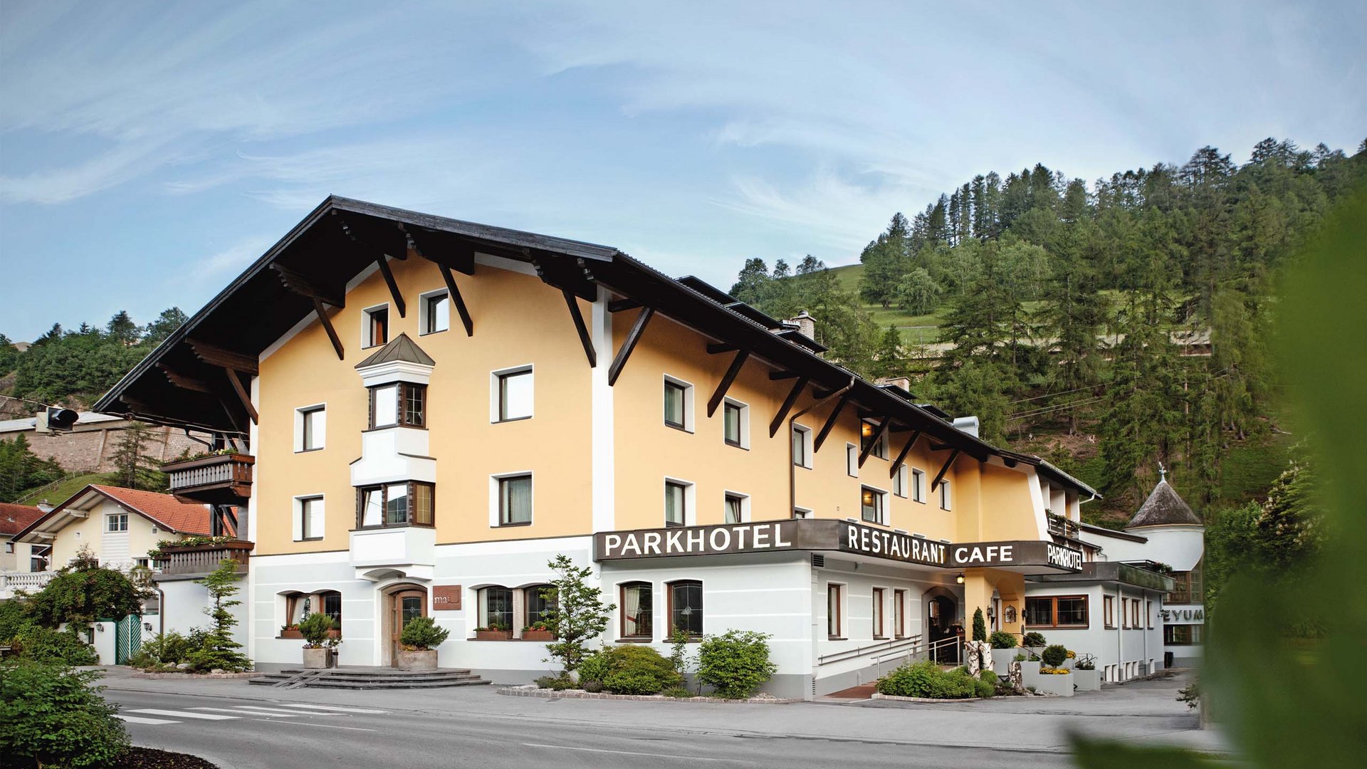 Dein Parkhotel in Matrei am Brenner Gelbes Parkhotel mit Restaurant und Café in einer Alpenlandschaft